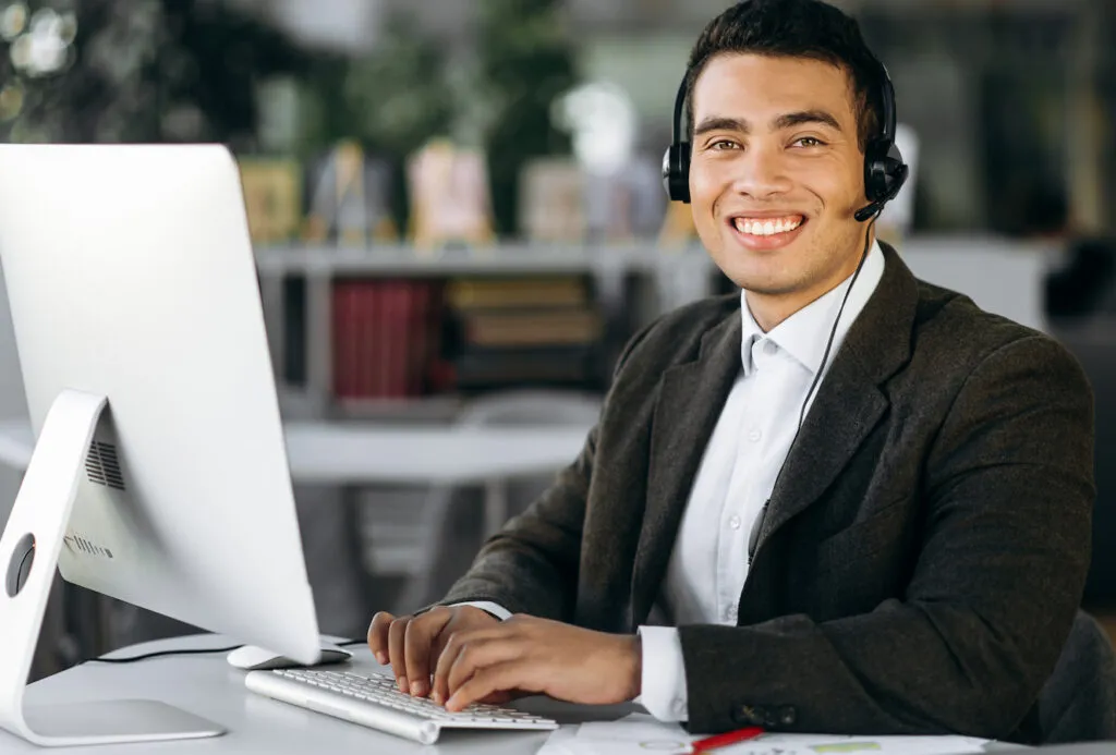 Un consejero trabaja en su escritorio con unos auriculares puestos.