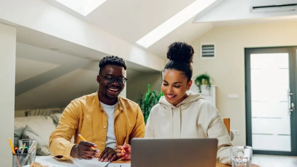 a young couple sitting with computer looking over their finances