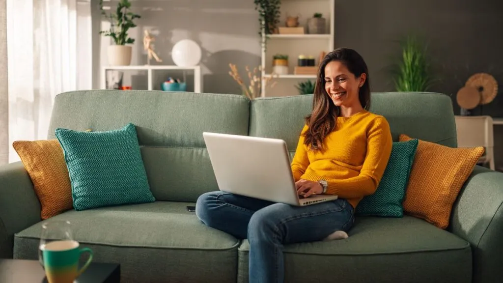 Woman in yellow sweater using laptop
