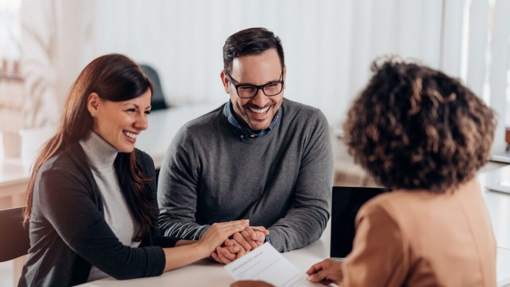 a smiling couple talking to a counselor